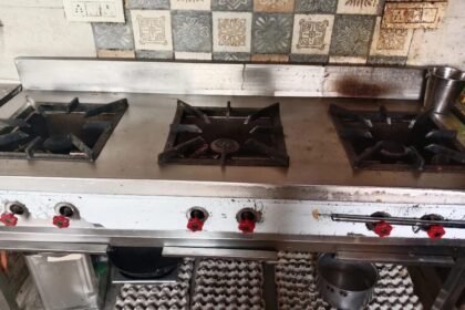 Three-burner commercial gas range in a restaurant kitchen