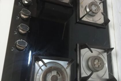 Four-burner glass hob burning a clean blue flame after repair